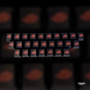 Close-up of individual Akatsuki red cloud keycaps on wooden table – ninja gaming theme