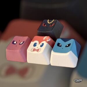 Close-up desk shot of glittery Pokemon keycaps inspired by Espeon, Eevee, Vaporeon, and Umbreon