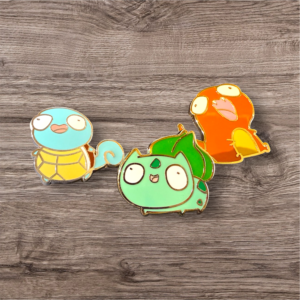 Close-up of Pokémon enamel pins set on wood surface