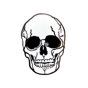 Front view of black and white anatomical skull enamel pin on white background