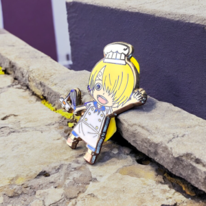 Sanji anime pin leaning on a rough stone ledge outdoors
