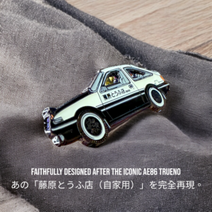 Initial D AE86 enamel pin showing black-and-white Trueno with Fujiwara Tofu Shop livery on gray fabric