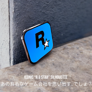 Rockstar Games enamel pin showing R and star logo leaning on stone surface