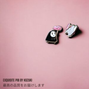 Spirited Away enamel pin showing No Face with pink lotus flower next to Totoro enamel pin on pink background
