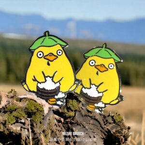 Spirited Away enamel pin showing two Otori-sama anime duck pins with rice buckets outdoors